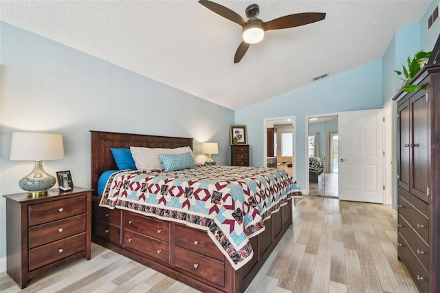 160 Sage Cir, Crystal Beach, FL 34681 - bedroom featuring vaulted ceiling, light wood-style floors, a textured ceiling, ceiling fan, and connected bathroom
