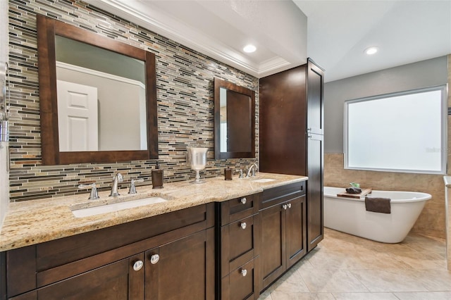160 Sage Cir, Crystal Beach, FL 34681 - bathroom with tile walls, a soaking tub, double vanity, backsplash, and crown molding