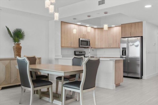 415 Island Way Unit 303, Clearwater Beach, FL 33767 - kitchen featuring appliances with stainless steel finishes, light countertops, recessed lighting, a chandelier, and light brown cabinets