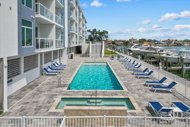 415 Island Way Unit 303, Clearwater Beach, FL 33767 - community pool with a hot tub, a water view, and a patio