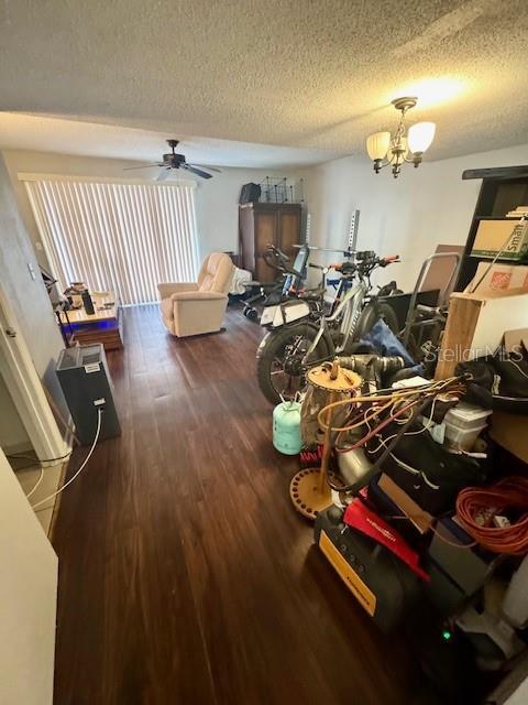 144 Douglas Rd W Unit F, Oldsmar, FL 34677 - living room featuring wood finished floors, a textured ceiling, a ceiling fan, and a chandelier