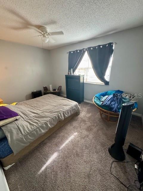 144 Douglas Rd W Unit F, Oldsmar, FL 34677 - bedroom featuring a textured ceiling, carpet flooring, and a ceiling fan