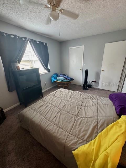 144 Douglas Rd W Unit F, Oldsmar, FL 34677 - carpeted bedroom featuring a textured ceiling, ceiling fan, and baseboards