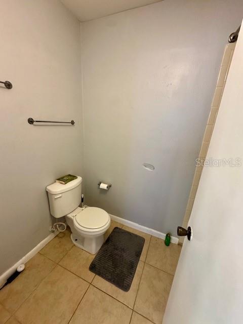 144 Douglas Rd W Unit F, Oldsmar, FL 34677 - bathroom with tile patterned flooring, toilet, and baseboards