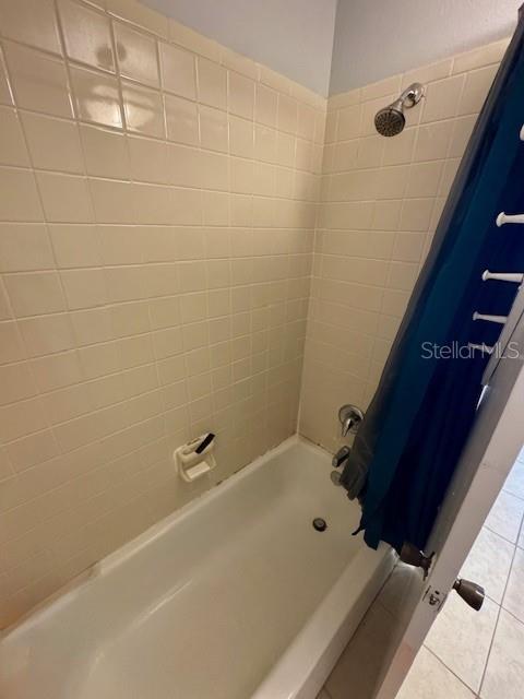 144 Douglas Rd W Unit F, Oldsmar, FL 34677 - bathroom with tile patterned flooring and shower / bath combination with curtain