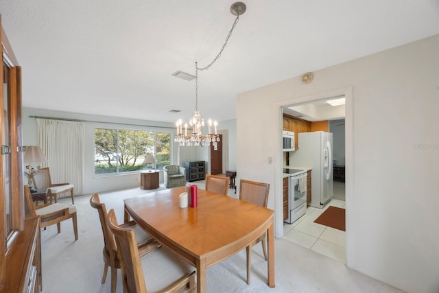 dining area featuring a chandelier and light carpet