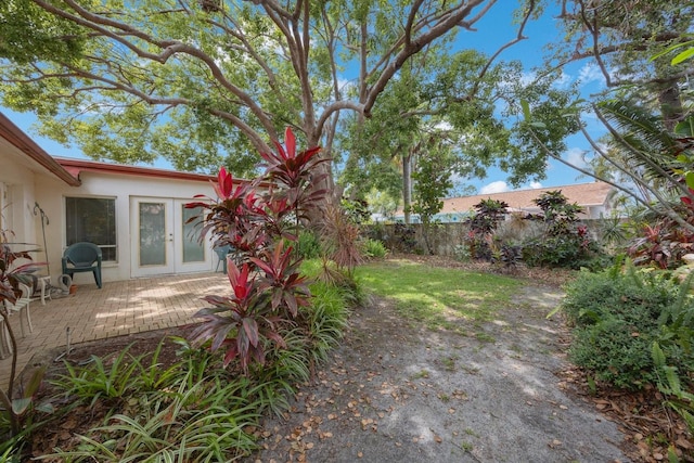 fenced yard featuring french doors and a patio area