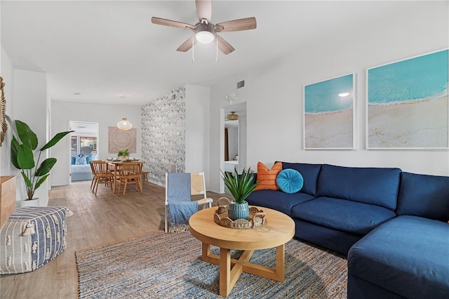 living area with wood finished floors and ceiling fan