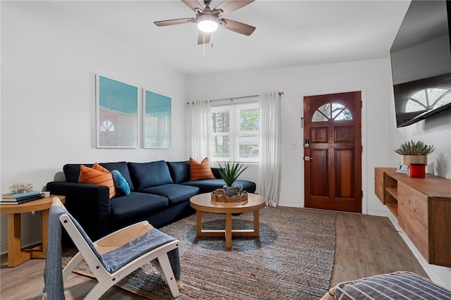 living area with light wood-style flooring and a ceiling fan