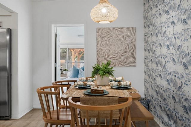 dining area with light wood-style flooring and baseboards