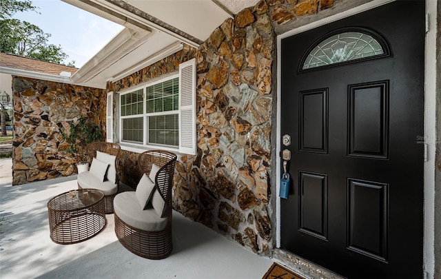 1402 Oleander Dr, Tarpon Springs, FL 34689 - doorway to property featuring stone siding and covered porch