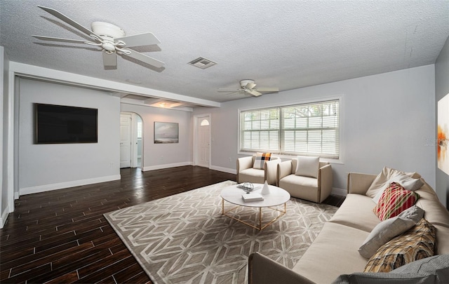 1402 Oleander Dr, Tarpon Springs, FL 34689 - living room with arched walkways, ceiling fan, baseboards, wood finished floors, and a textured ceiling