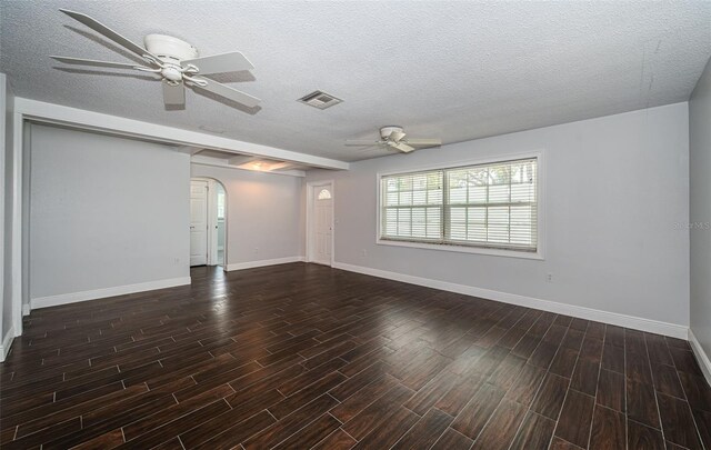1402 Oleander Dr, Tarpon Springs, FL 34689 - spare room featuring ceiling fan, arched walkways, wood finished floors, baseboards, and a textured ceiling