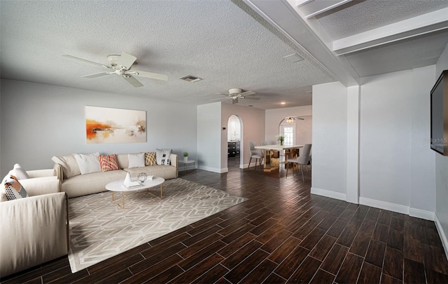1402 Oleander Dr, Tarpon Springs, FL 34689 - living room with a ceiling fan, arched walkways, a textured ceiling, baseboards, and wood finished floors
