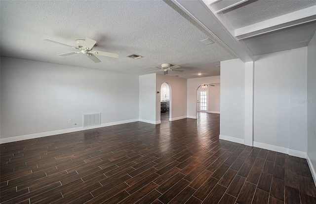 1402 Oleander Dr, Tarpon Springs, FL 34689 - unfurnished living room featuring a ceiling fan, arched walkways, a textured ceiling, wood finished floors, and baseboards