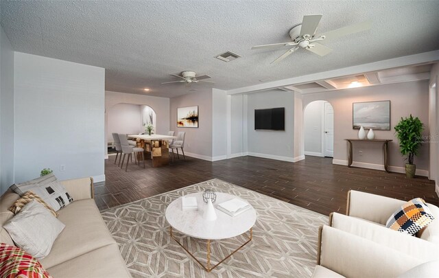 1402 Oleander Dr, Tarpon Springs, FL 34689 - living room featuring arched walkways, ceiling fan, wood finished floors, baseboards, and a textured ceiling