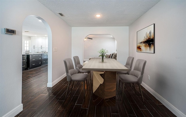 1402 Oleander Dr, Tarpon Springs, FL 34689 - dining area with arched walkways, wood tiled floors, baseboards, and a textured ceiling