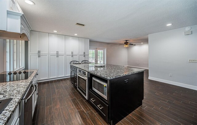 1402 Oleander Dr, Tarpon Springs, FL 34689 - kitchen featuring appliances with stainless steel finishes, wood finish floors, french doors, baseboards, and a textured ceiling