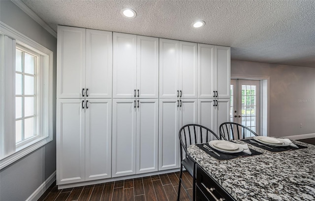 1402 Oleander Dr, Tarpon Springs, FL 34689 - kitchen with white cabinetry, wood finish floors, a textured ceiling, and baseboards