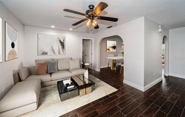 1402 Oleander Dr, Tarpon Springs, FL 34689 - living area featuring arched walkways, a ceiling fan, baseboards, wood tiled floors, and a textured ceiling
