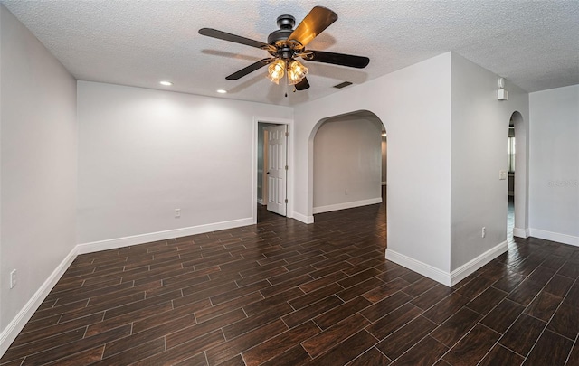 1402 Oleander Dr, Tarpon Springs, FL 34689 - spare room featuring arched walkways, a ceiling fan, wood finished floors, baseboards, and a textured ceiling