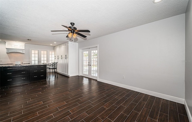 1402 Oleander Dr, Tarpon Springs, FL 34689 - unfurnished living room featuring baseboards, french doors, a ceiling fan, dark wood-style flooring, and a textured ceiling