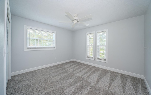 1402 Oleander Dr, Tarpon Springs, FL 34689 - empty room with healthy amount of natural light, carpet flooring, baseboards, and ceiling fan