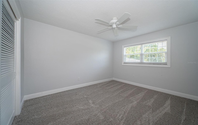 1402 Oleander Dr, Tarpon Springs, FL 34689 - empty room with a ceiling fan, dark carpet, a textured ceiling, and baseboards