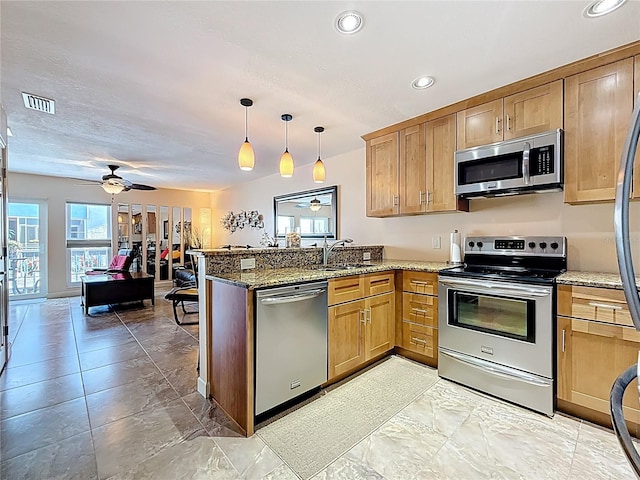 230 Medallion Blvd Unit G, Madeira Beach, FL 33708 - kitchen featuring appliances with stainless steel finishes, a peninsula, a sink, recessed lighting, and stone counters