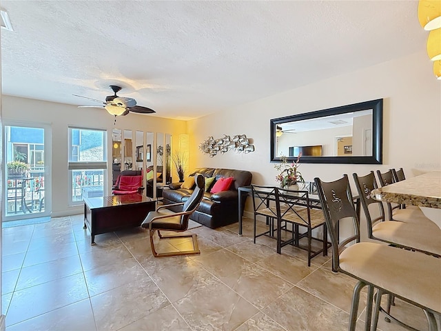 230 Medallion Blvd Unit G, Madeira Beach, FL 33708 - living area featuring a textured ceiling, a ceiling fan, and tile patterned floors