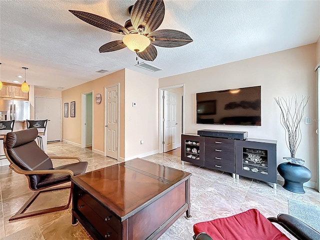 230 Medallion Blvd Unit G, Madeira Beach, FL 33708 - living area with a textured ceiling, a ceiling fan, and baseboards