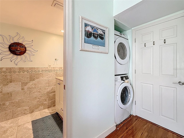 230 Medallion Blvd Unit G, Madeira Beach, FL 33708 - laundry area with stacked washing machine and dryer, tile walls, and wainscoting