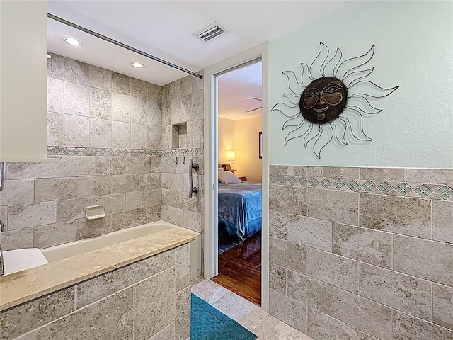 230 Medallion Blvd Unit G, Madeira Beach, FL 33708 - bathroom with tile walls, connected bathroom, tiled shower, tile patterned floors, and a wainscoted wall