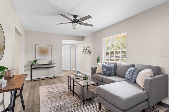living room featuring a ceiling fan, wood finished floors, and baseboards
