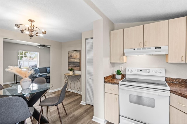 kitchen with under cabinet range hood, electric stove, dark countertops, wood finished floors, and light brown cabinets