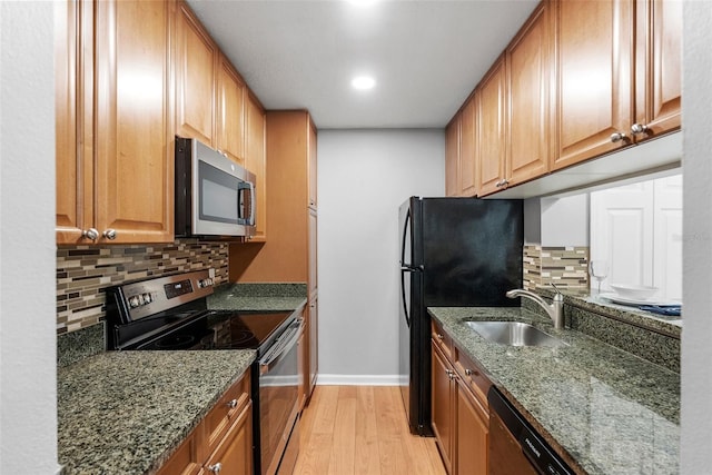 11901 4th St N Unit 8207, Saint Petersburg, FL 33716 - kitchen featuring appliances with stainless steel finishes, a sink, light wood finished floors, baseboards, and decorative backsplash