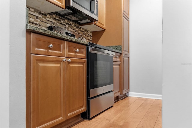 11901 4th St N Unit 8207, Saint Petersburg, FL 33716 - kitchen featuring stainless steel microwave, light wood-style floors, and decorative backsplash