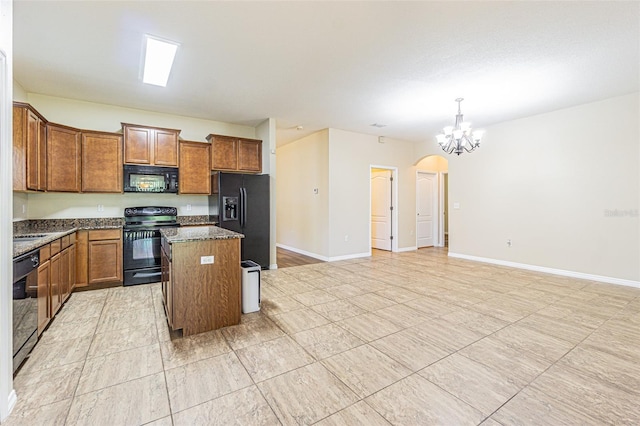 kitchen with black appliances, a center island, brown cabinets, and a chandelier