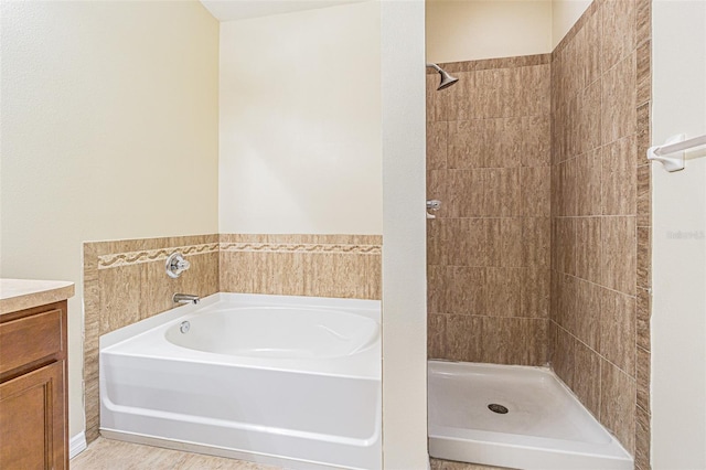 bathroom featuring a stall shower, a garden tub, and vanity