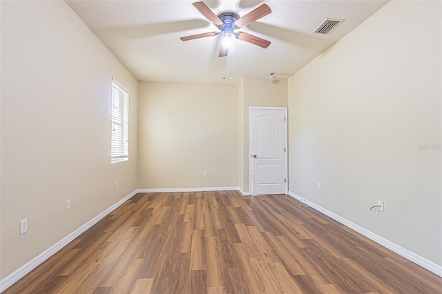 unfurnished room featuring wood finished floors, a ceiling fan, and baseboards