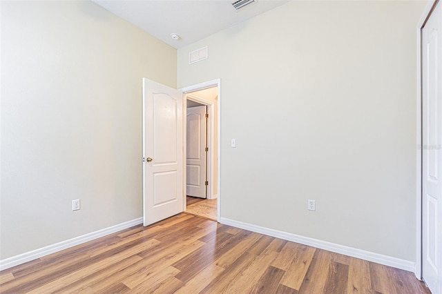 unfurnished bedroom with light wood-style flooring, baseboards, and a closet