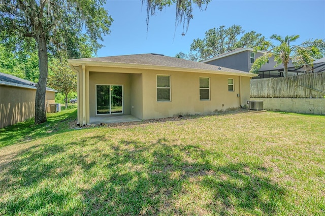 rear view of property with stucco siding, cooling unit, and a patio