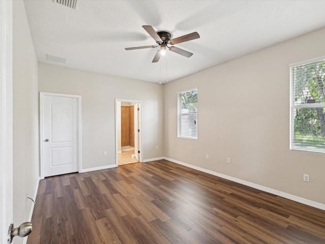 12212 Mcmullen Loop, Riverview, FL 33569 - unfurnished bedroom with dark wood-style floors, baseboards, connected bathroom, and ceiling fan