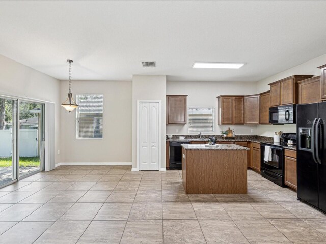 12212 Mcmullen Loop, Riverview, FL 33569 - kitchen featuring black appliances, a center island, pendant lighting, a sink, and baseboards