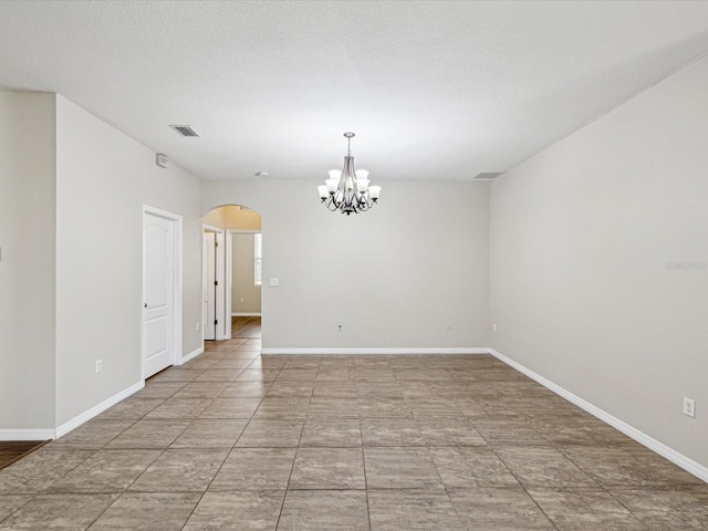 12212 Mcmullen Loop, Riverview, FL 33569 - empty room featuring arched walkways, a chandelier, baseboards, and a textured ceiling