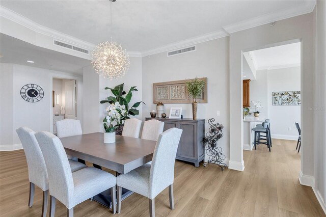 140 Riviera Dunes Way Unit 1203, Palmetto, FL 34221 - dining space featuring light wood finished floors, a chandelier, crown molding, and baseboards