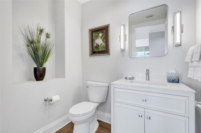 140 Riviera Dunes Way Unit 1203, Palmetto, FL 34221 - bathroom featuring baseboards, toilet, wood finished floors, and vanity