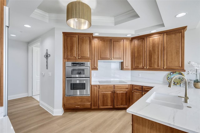 140 Riviera Dunes Way Unit 1203, Palmetto, FL 34221 - kitchen with light wood finished floors, a sink, double oven, brown cabinetry, and crown molding