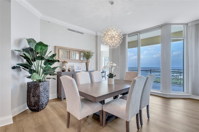140 Riviera Dunes Way Unit 1203, Palmetto, FL 34221 - dining space with plenty of natural light, light wood-style floors, a chandelier, crown molding, and a water view