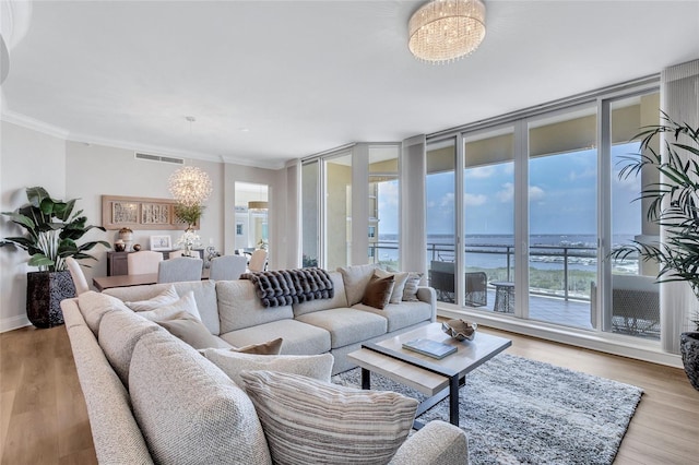 140 Riviera Dunes Way Unit 1203, Palmetto, FL 34221 - living room featuring a chandelier, plenty of natural light, a water view, crown molding, and wood finished floors